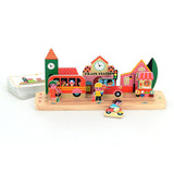 Wooden toy town set by Vilac featuring a train station, red bus, and small figures on a wooden track base.