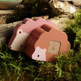 Vilac wooden hedgehog toy with numbered stacking blocks on a mossy forest floor background.