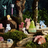 Vilac wooden animal counting and stacking toys arranged in a forest display with mossy logs and a pear.