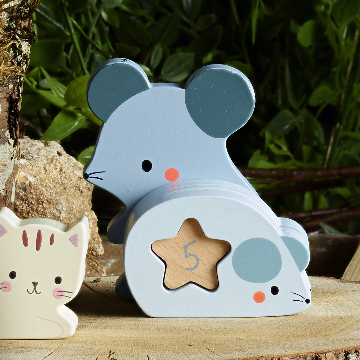 Vilac wooden mouse counting toy with number 5 in a star cutout on a log outside.