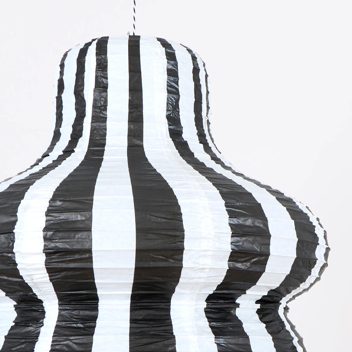 Close-up of a black and white vertically striped paper lantern showing detailed texture.