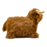 Fluffy brown plush toy resembling a Highland cow, with long fur and curved horns, set against a white background, conveying a cozy and whimsical feel.