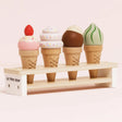 Four wooden toy ice cream cones in different flavors on a display stand.