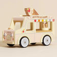 A pastel yellow and pink wooden toy ice cream van with a large ice cream cone on the roof.
