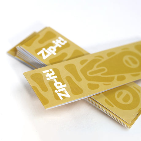 Yellow Zip-it! game card deck spread out on a white surface with printed logos.